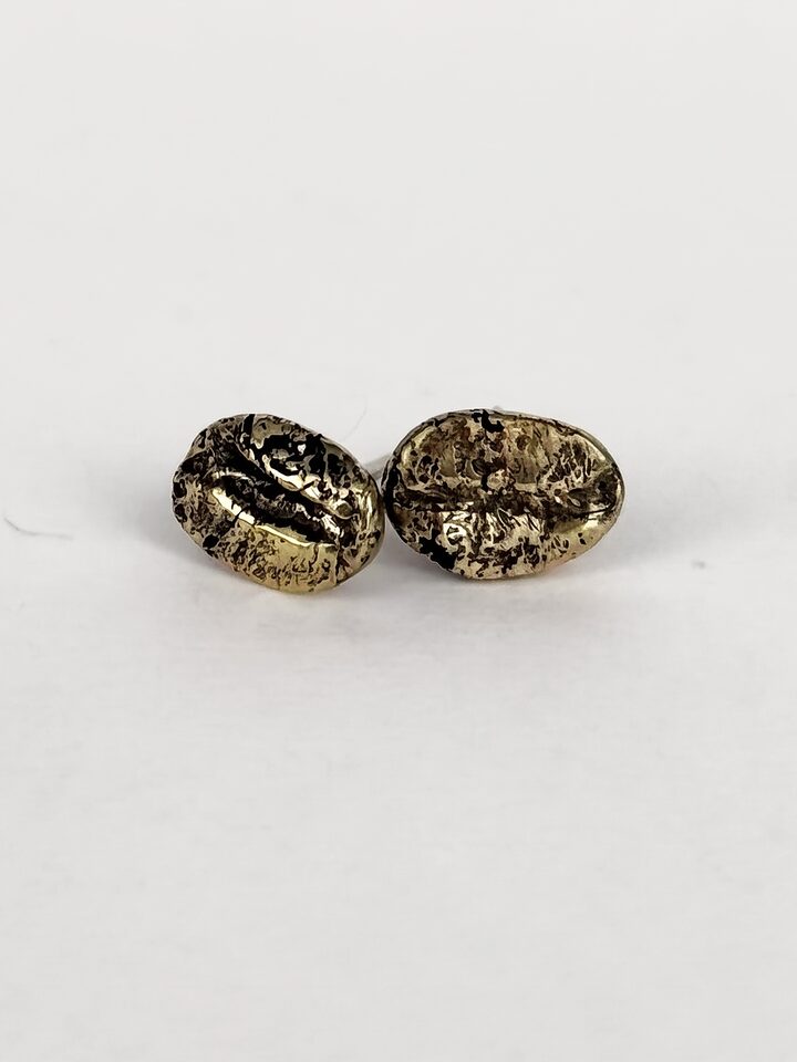 Two golden bronze coffee bean stud earrings with a textured surface, on a white background.