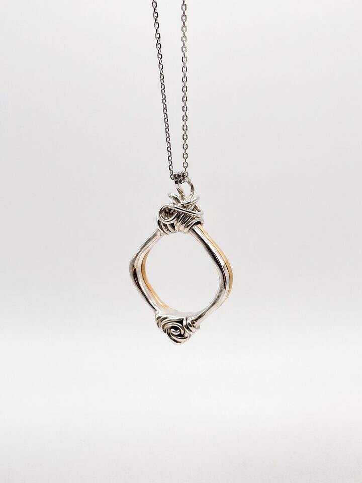 Silver wire pendant with an open square frame, a knotted top, a small rose at the base and a golden inner edge, on a fine chain.